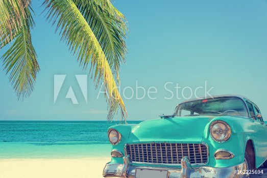 Picture of Classic car on a tropical beach with palm tree vintage process